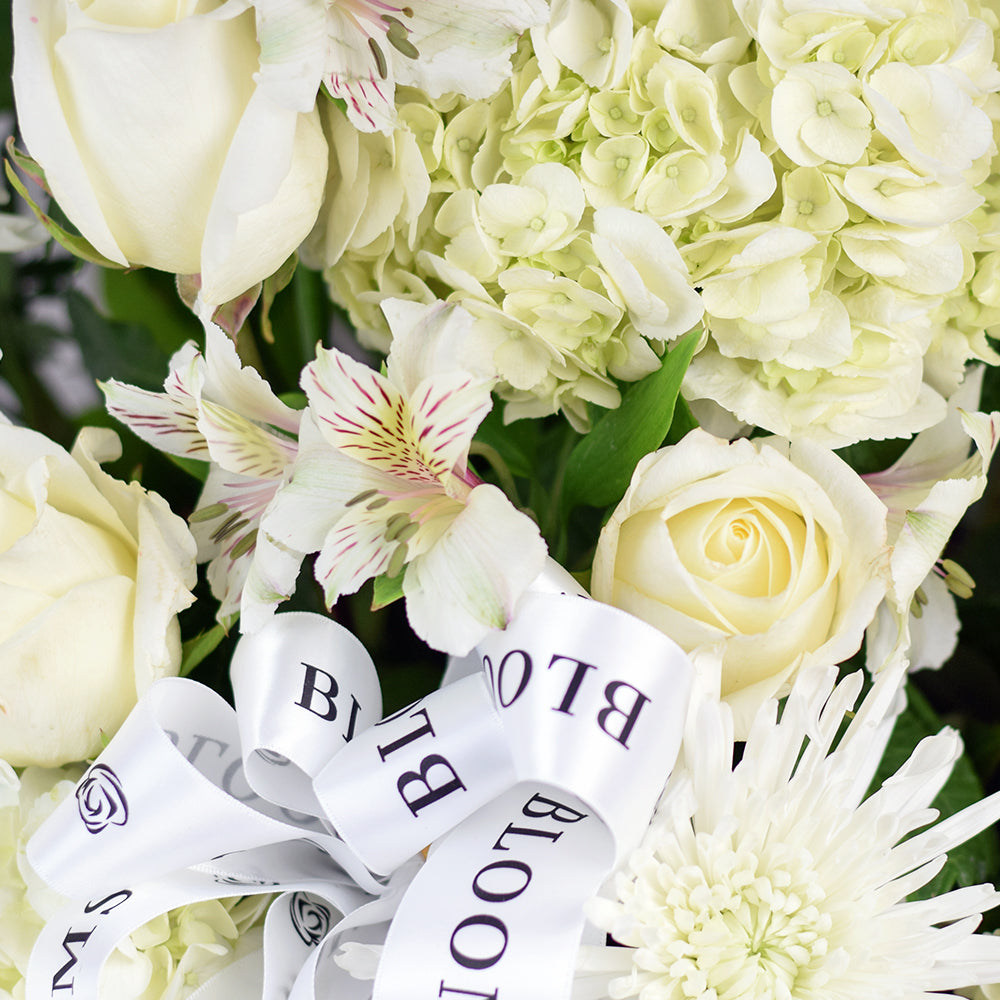 Luminous white mixed flower arrangement in basket. Same Day Toronto Delivery