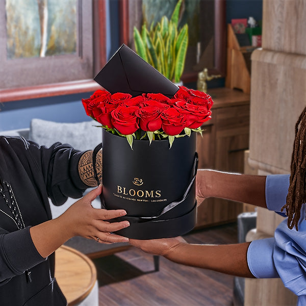 Person receiving a black box of red roses from Toronto Blooms  same day delivery