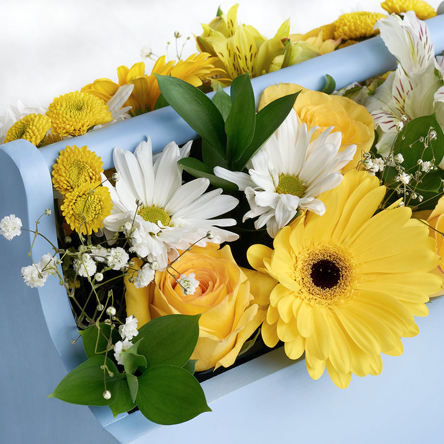 Yellow and white mixed floral arrangement in a blue toolbox. Same Day Toronto Delivery